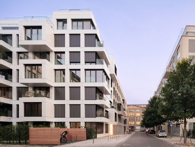 Modernt flerbostadshus på stadsgata med balkonger och fasadfönster