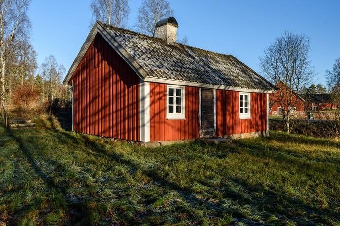Rött äldre trähus på landsbygden med grått tegeltak