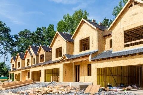Pågående tillbyggnad av ett större trähus på landsbygden